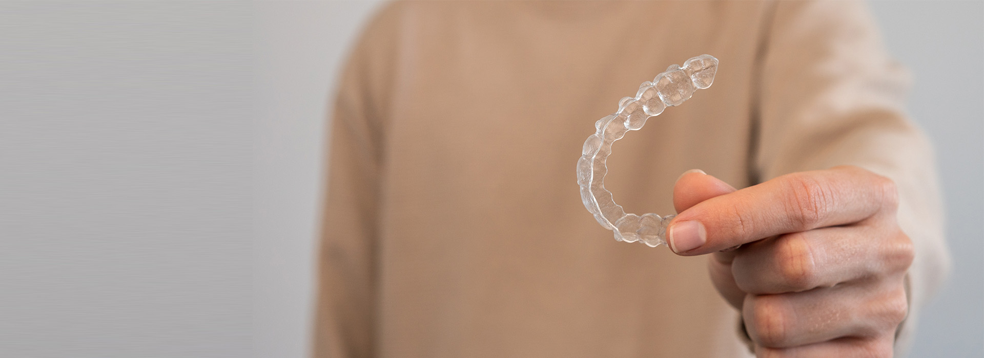 The image shows a person holding up a transparent, bubble-like object with their hand.
